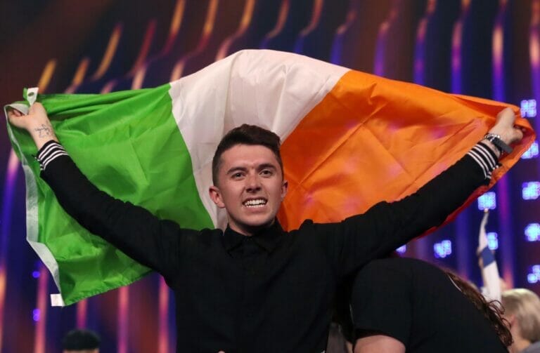 man, holding up, irish flag