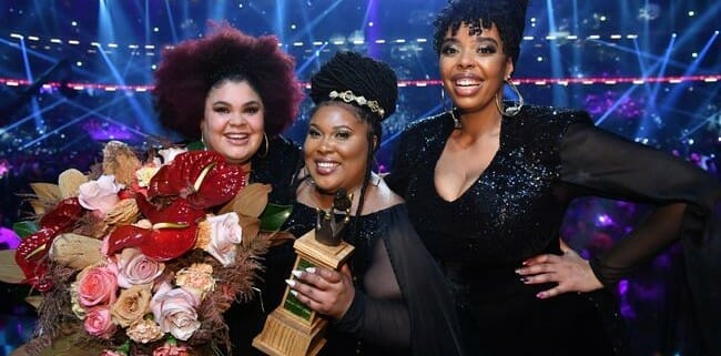 Three african american women posing for a photo with their awards.